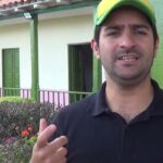 Hombre con gorra verde y amarilla gesticulando frente a una casa con porche y jardín; Patti LuPone se retracta tras acusaciones de bullying en Broadway: la sorprendente verdad que revela sobre su error