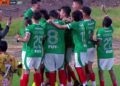 Jugadores de fútbol con camisetas verdes celebrando un gol en el campo, afición y entrenador cerca — Dónde vive Mikecrack: descubre la casa del youtuber más famoso