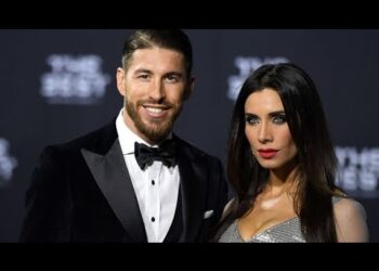 Mujer y hombre posando en alfombra roja con esmoquin y vestido brillante, parejas que marcaron su vida amorosa