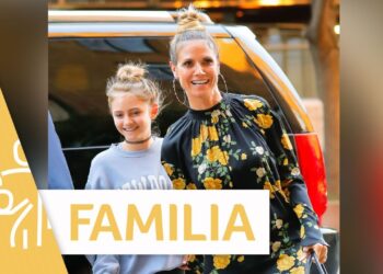 Mujer adulta sonriente con una niña junto a un vehículo, momento familiar que sugiere maternidad y cariño