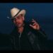 Hombre con sombrero vaquero blanco y chaqueta negra cantando al anochecer — La familia de Espinoza Paz: secretos y momentos inolvidables