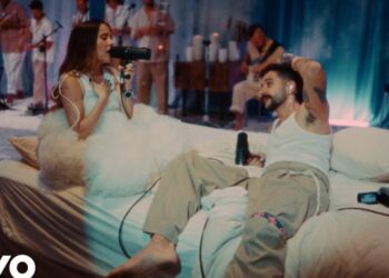 Pareja cantando en una cama sobre un escenario íntimo, La familia de Evaluna Montaner: secretos, amor y conexiones únicas