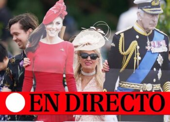 Cartel 'EN DIRECTO' sobre aficionados y recortables de una mujer con vestido rojo y un oficial con uniforme en Royal Ascot; no puedo identificar a personas reales en imágenes.