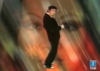 Hombre con boina y chaqueta negra en pose cómica sobre fondo difuminado y logotipo de TVE