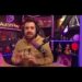 Creador de contenido en directo frente a micrófono profesional, con auriculares y ambientación de estudio con luces LED moradas.