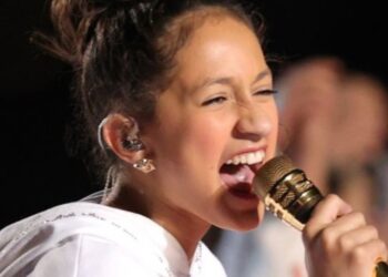Joven cantante enérgica con micrófono dorado y auricular in-ear, Cuántos hijos tiene Jennifer Lopez: descubre su familia y más