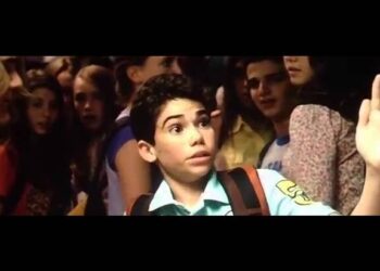 Joven estudiante sorprendido en un pasillo escolar lleno de compañeros con mochila al hombro; Descubre el emocionante drama de Netflix basado en una novela bestseller que reúne a las estrellas de Line of Duty y The Capture