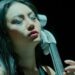 ¿Cuánto cobra Hans Zimmer? Descubre su impresionante fortuna 27 Mujer concentrada tocando un violonchelo eléctrico en primer plano, ¿Cuánto cobra Hans Zimmer? Descubre su impresionante fortuna