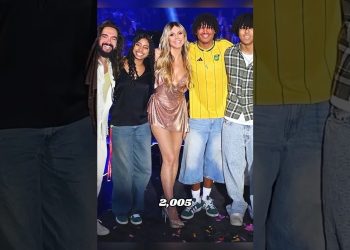 Modelo en vestido brillante posa junto a su hijo y un grupo de jóvenes sobre un escenario iluminado en una noche de moda que no te puedes perder