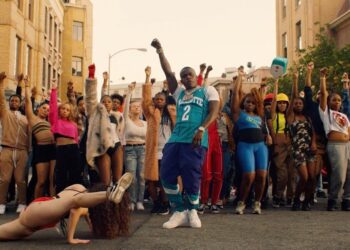 Eminem: Descubre de dónde es el rapero que revolucionó el hip hop en una escena urbana con multitud y bailarines alzando el puño