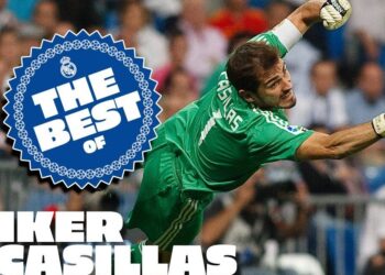 Portero en acción estirándose para atrapar un balón durante un partido, con un sello 'The Best of' y emblemas del club.