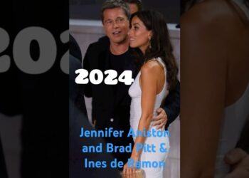 Pareja elegante en evento público, ella deslumbrante en un vestido blanco mientras él la abraza y sonríe.