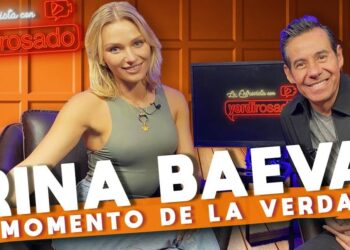 Entrevista en estudio con una actriz rubia y un presentador sonriente; descubre de dónde es esta actriz y su fascinante historia personal.