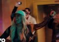 Mujer rubia sonriente con gorra en una fiesta íntima entre luces cálidas y gente detrás — La familia de J Balvin: secretos y lazos que la unen al éxito