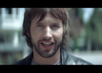 Retrato cercano de un cantante con barba y chaqueta de cuero al aire libre, ¿De dónde es este artista? Descubre su origen y curiosidades