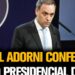 Hombre en traje frente a un atril y micrófonos en una conferencia, Dónde trabaja Javier Milei: descubre su sorprendente trayectoria