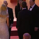 Grupo de invitados en gala elegante conversando en una escalinata; ¿Cuánto cobra Jeff Bezos al minuto? Descubre su asombroso ingreso