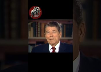 Hombre mayor en traje y corbata en una entrevista frente a una estantería de libros, Descubre a los 7 hijos de John Wayne que conquistaron Hollywood como él
