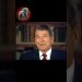Hombre mayor en traje y corbata en una entrevista frente a una estantería de libros, Descubre a los 7 hijos de John Wayne que conquistaron Hollywood como él