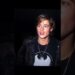 Joven con chaqueta de cuero y camiseta con emblema de murciélago, collar visible y expresión pensativa bajo luz tenue — Las parejas de Johnny Depp: amor, desamor y secretos revelados.