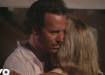 Pareja abrazada en un momento íntimo y melancólico en interior con poca luz.