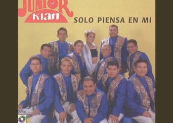 Portada de grupo musical con varios integrantes vestidos de azul y una vocalista central; ¿Cuánto cobra Junior Klan? Descubre su sorprendente salario aquí