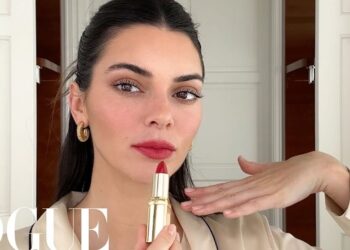 Mujer en primer plano aplicando lápiz labial rojo; ¿Cuánto cobra Kendall Jenner por publicación en redes sociales?