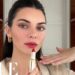 Mujer en primer plano aplicando lápiz labial rojo; ¿Cuánto cobra Kendall Jenner por publicación en redes sociales?