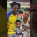 Mujer y varios niños posando sonrientes en un estadio con aficionados alrededor