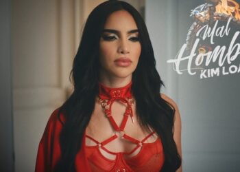 Descubre a los adorables hijos de Kimberly Loaiza y JD Pantoja en una imagen promocional que muestra a una mujer de cabello oscuro con vestimenta roja y logotipo musical
