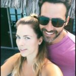 Pareja sonriente en un ambiente tropical disfrutando de la compañía familiar, transmitiendo amor, risas y momentos inolvidables.