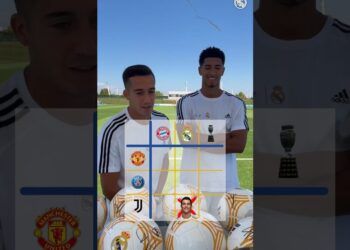 Dos futbolistas con camiseta de entrenamiento del Real Madrid junto a varios balones sobre el césped