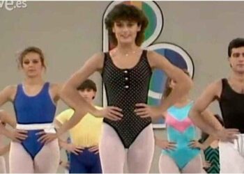 Grupo de clase de aeróbic retro con participantes en mallas y leotardos, manos en la cintura; ¿Qué fue de Eva Nasarre? La verdad detrás de su vida actual
