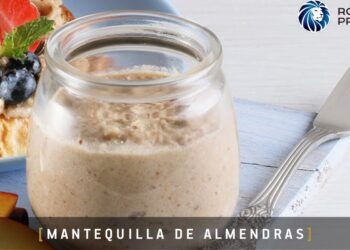 Frasco de mantequilla de almendras en un tarro junto a tostadas con fresas y arándanos y un cuchillo sobre tabla, Descubre la receta de s’mores más deliciosa que un nutricionista aprueba y transforma tu día nacional de s’mores en una verdadera fiesta de sabor
