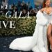 Descubre los looks más impactantes de la Met Gala 2025 que están rompiendo Internet en tiempo real: mujer en la alfombra roja con abrigo blanco de piel y vestido plateado con abertura.