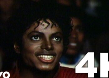 Persona sonriente con rizos vista desde cerca entre el público en un concierto