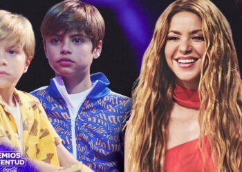 Mujer sonriente de cabello largo junto a dos niños en un escenario, transmitiendo unidad familiar y emoción.