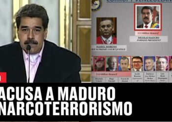 Figura política hablando frente a micrófono junto a tablero de recompensas millones dolares 16