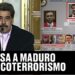Figura política hablando frente a micrófono junto a tablero de recompensas millones dolares 16