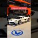 Ferrari blanco en exhibición sobre plataforma junto a transporte, imagen pensada para Neymar: Descubre cuánto cobra y los secretos de su contrato