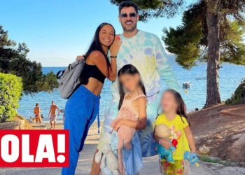 Familia disfrutando en la playa con dos niñas y dos adultos sonriendo bajo el sol