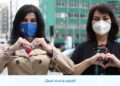 Dos mujeres con mascarillas formando corazones con las manos en un entorno urbano, ¿Quién es el esposo de Olga Zumarán? Descubre su nueva relación