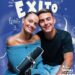 Pareja sonriente junto a un micrófono sobre fondo azul con ilustraciones y la palabra "Éxito"