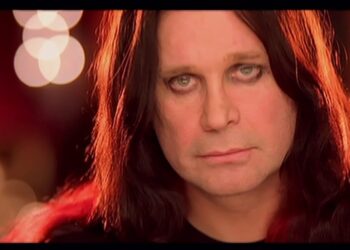 Primer plano de una persona de cabello largo y oscuro con maquillaje en los ojos y luz cálida