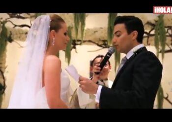 Pareja intercambiando votos en una ceremonia de boda, la novia con velo y el novio hablando al micrófono.