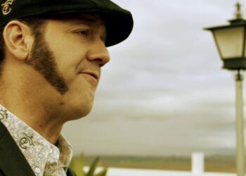 Hombre de perfil con boina y patillas junto a un farol, Cache de Paco Candela: descubre su precio y cómo contratarlo