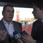 Dos comentaristas deportivos en una cabina del estadio dando una entrevista con micrófono visible