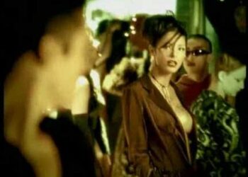 Persona no identificada en un club nocturno con iluminación cálida y gente alrededor; ¿Con quién está casada Paulina Rubio? Descubre su vida amorosa