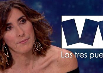 Retrato de una mujer presentadora en primer plano en un plató junto al logo del programa Las tres puertas