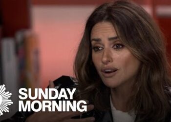 Mujer en primer plano durante una entrevista televisiva, gesticulando con expresión seria en un plató